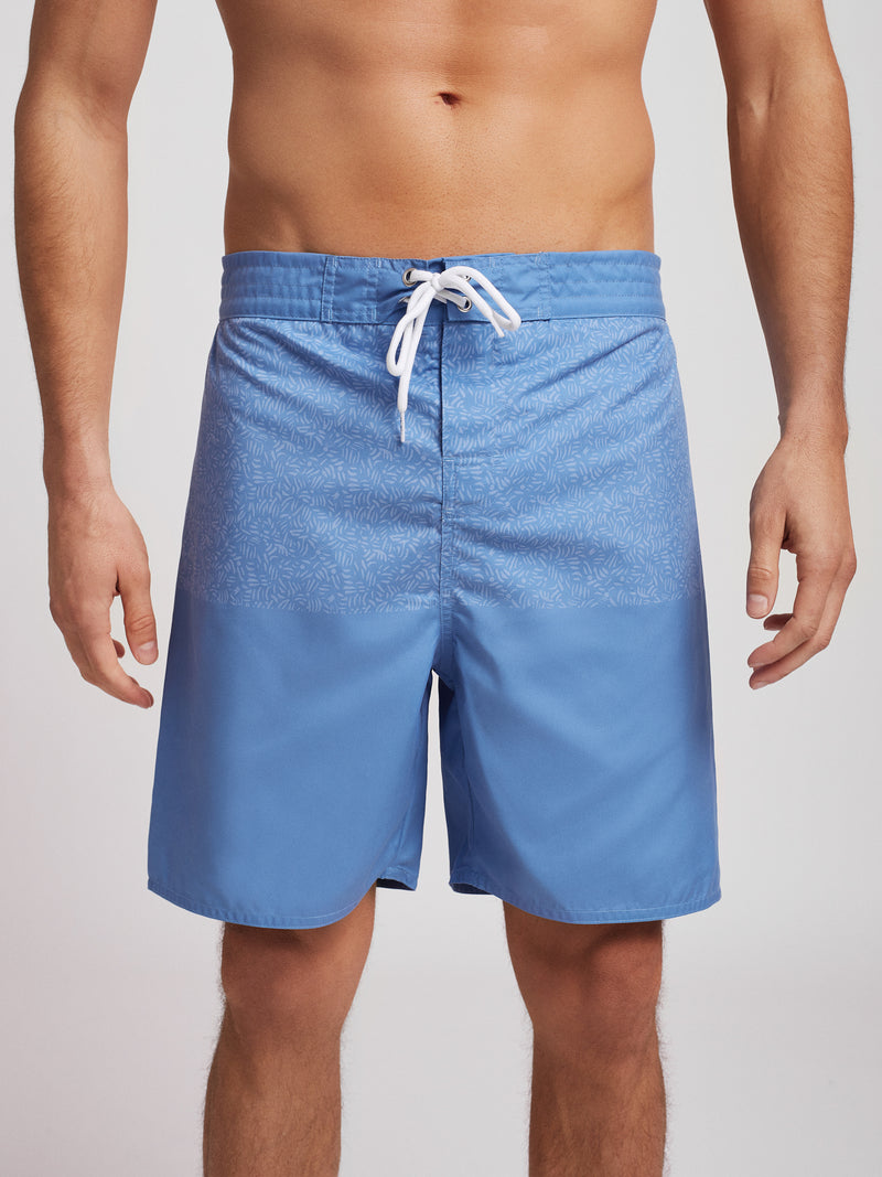 Pantalones cortos de surfista azul claro con hojas estampadas